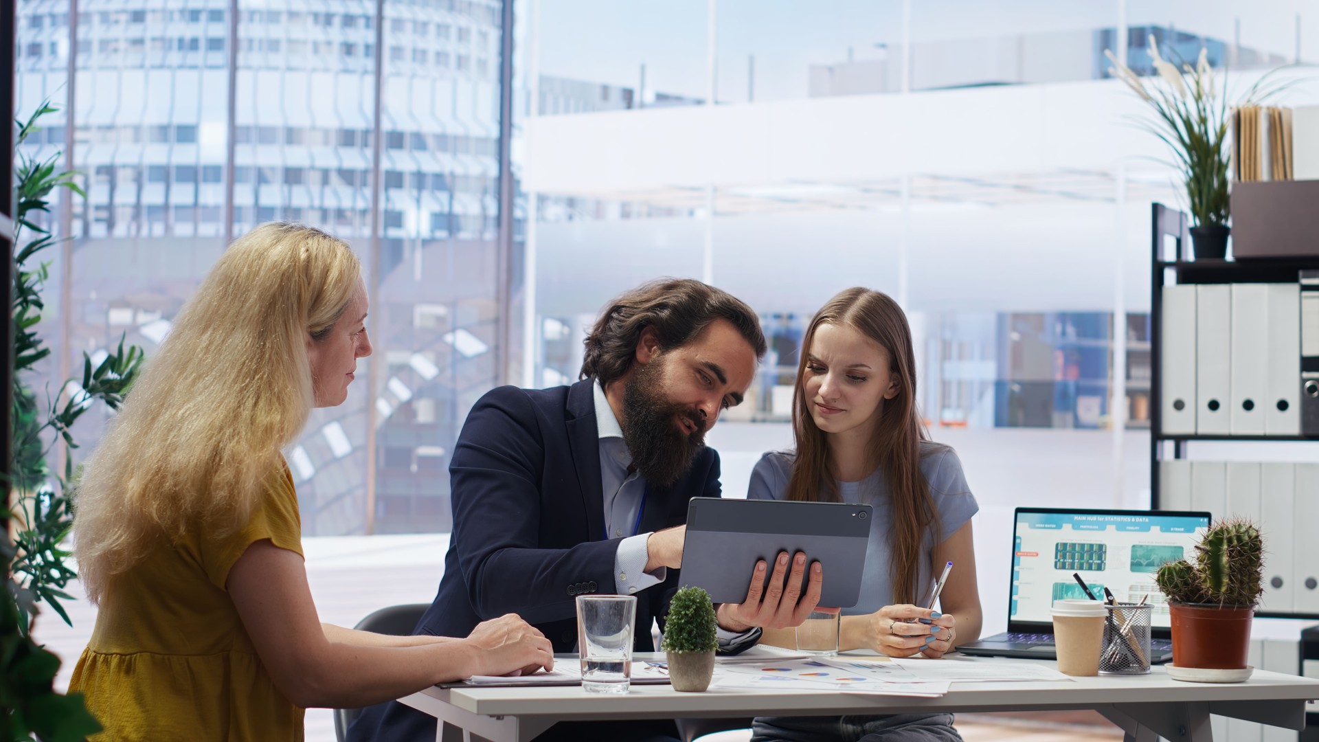 Agent in office assisting mother and daughter with investment portfolio