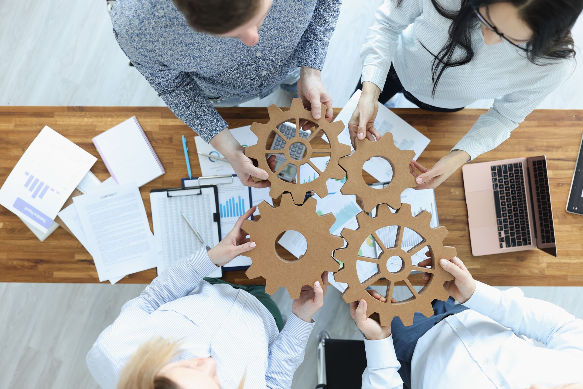 Employees in office connect gears in place